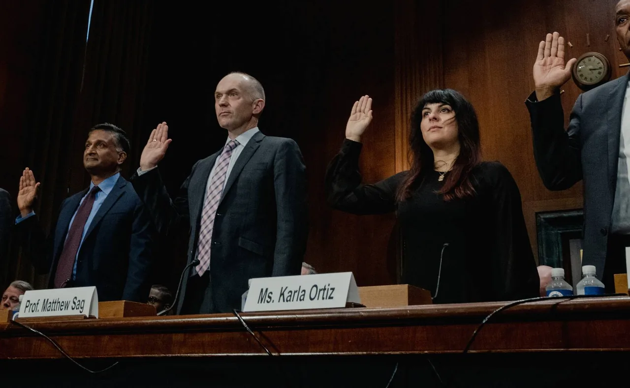 Four witnesses stand with their right hands raised at a Senate hearing table. Name cards on the table read Prof. Matthew Sag and Ms. Karla Ortiz.